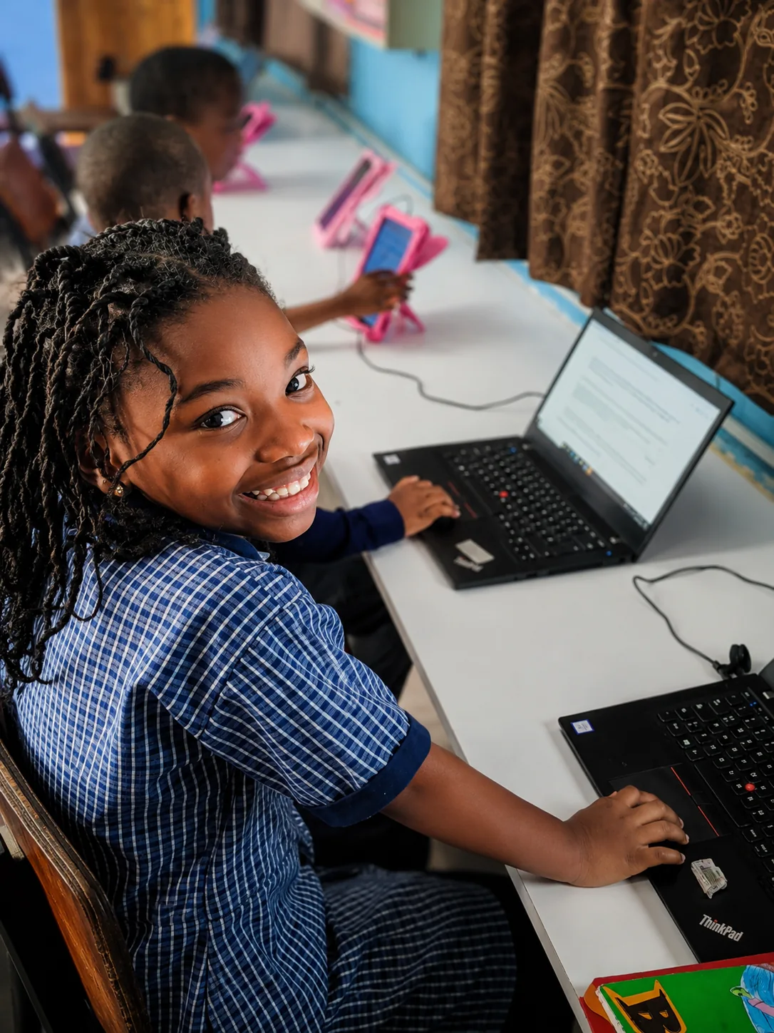 Smiling pupil working on a laptop